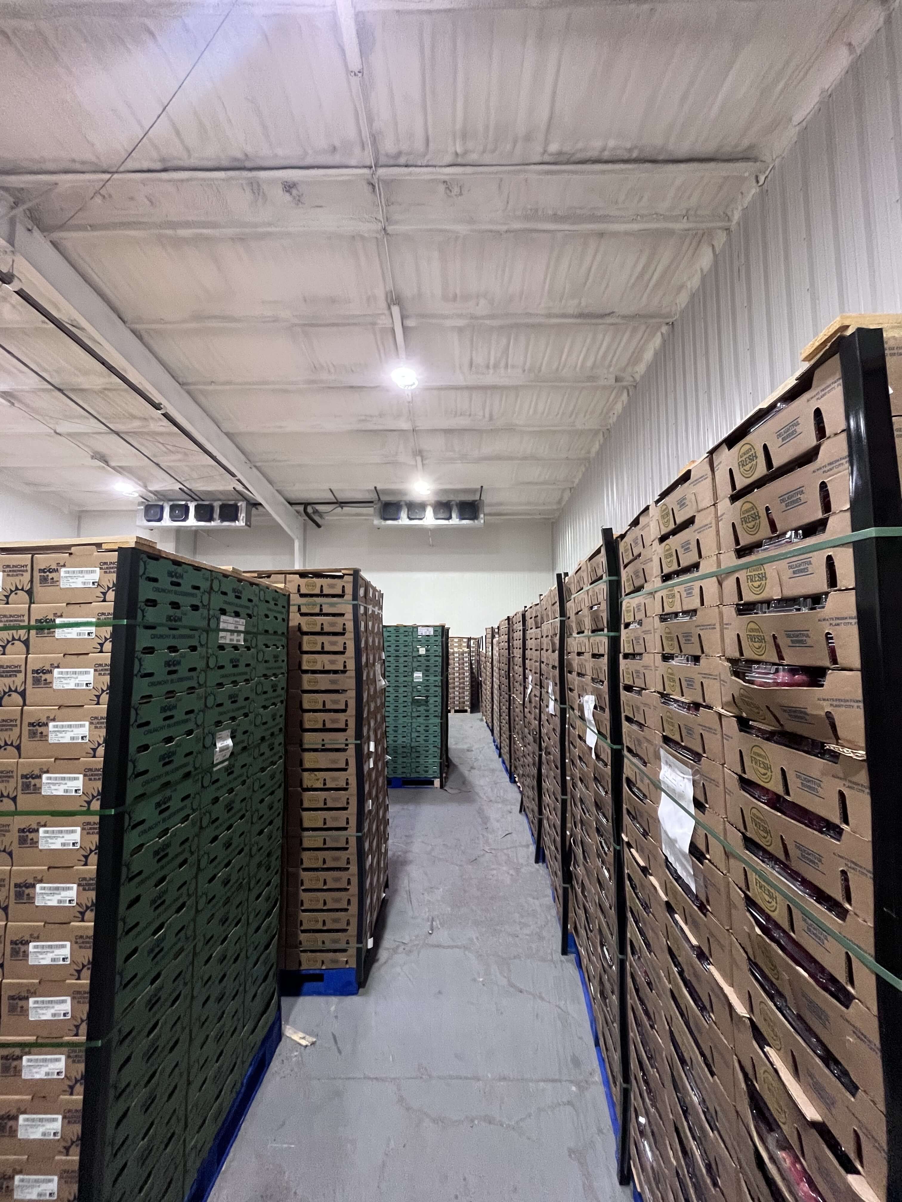 Cold storage room with stacked produce pallets and air diffusers