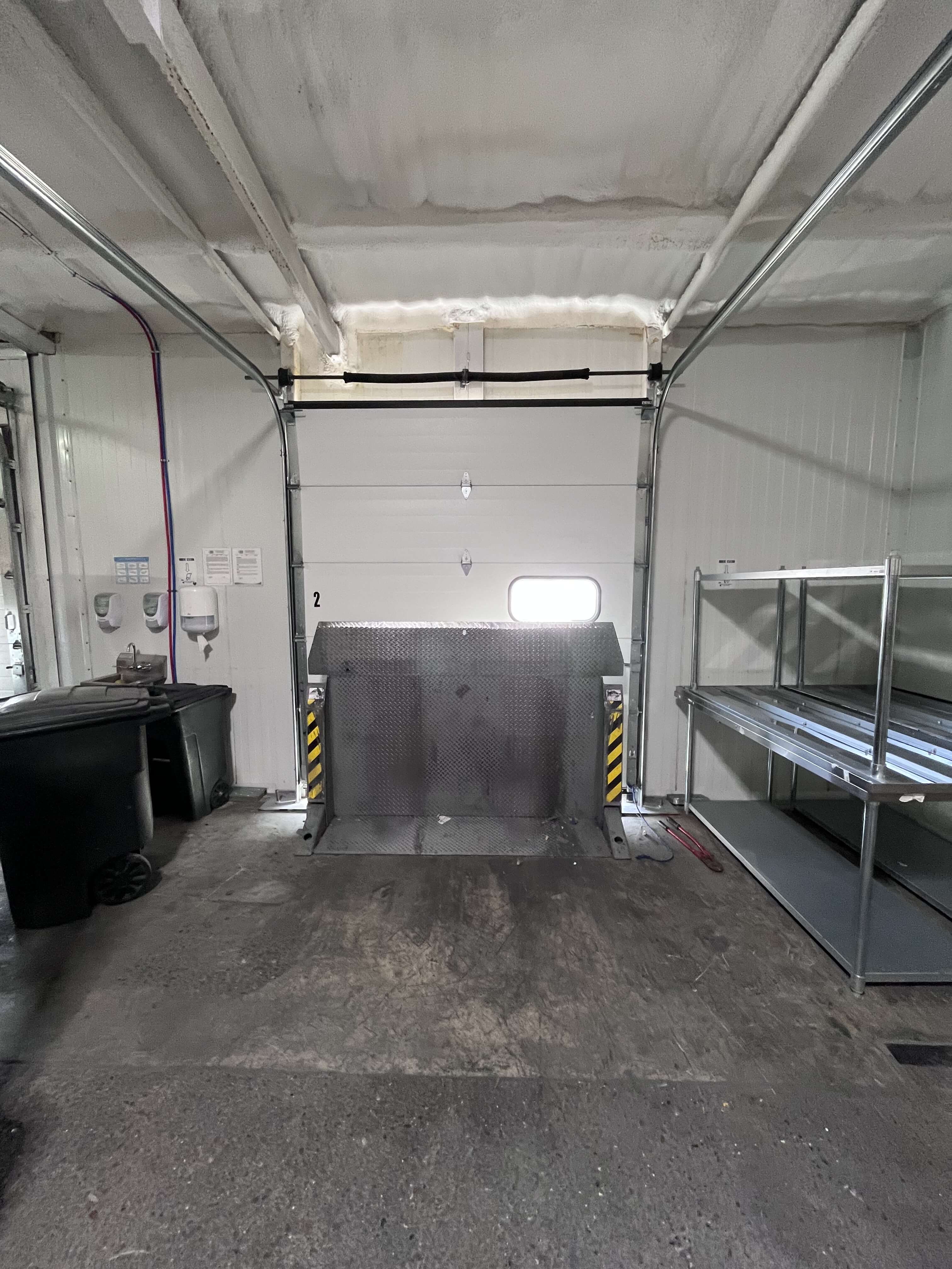 Loading dock interior with dock leveler and inspection station