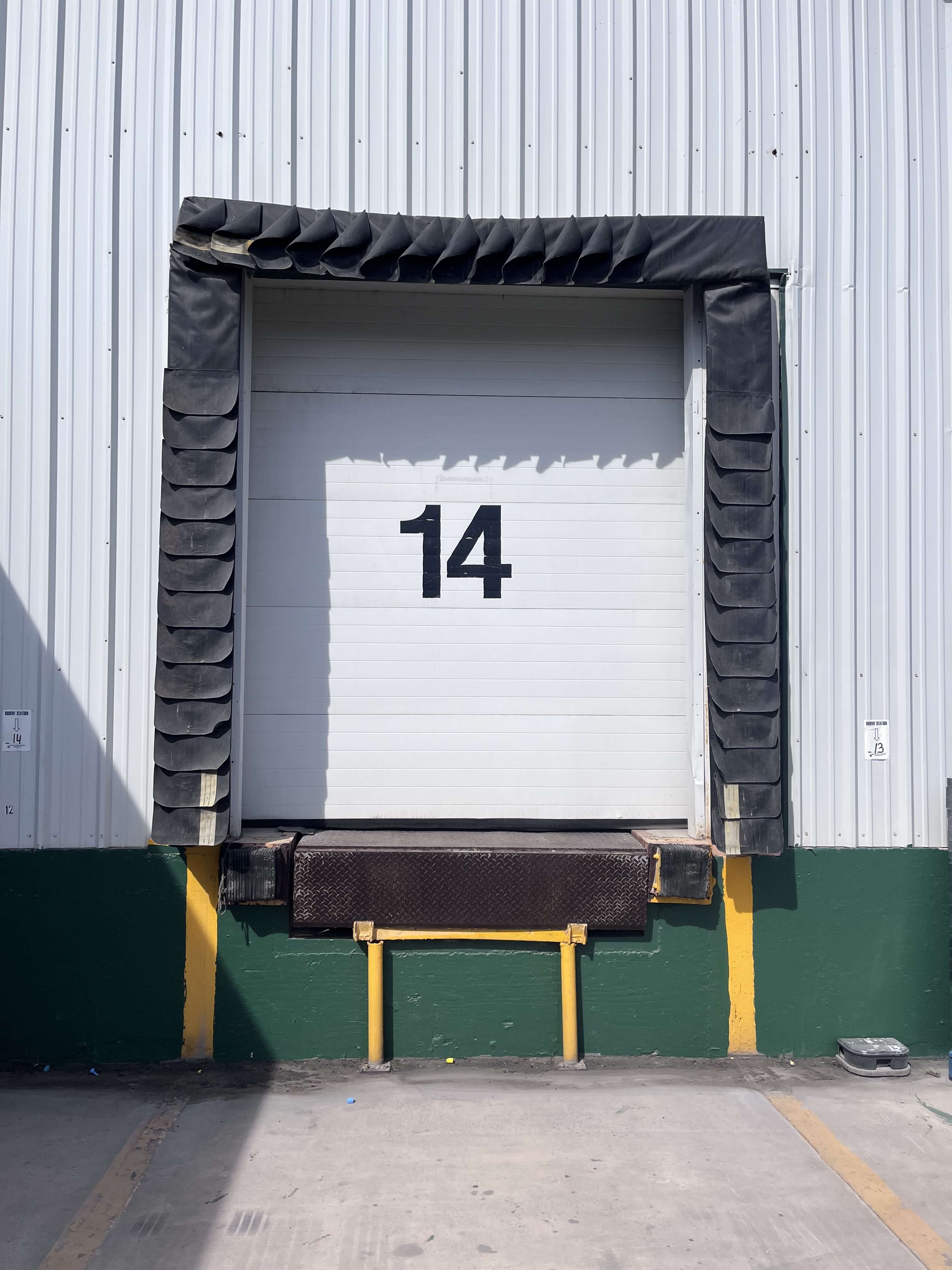 Exterior loading dock door number 14 with dock bumpers