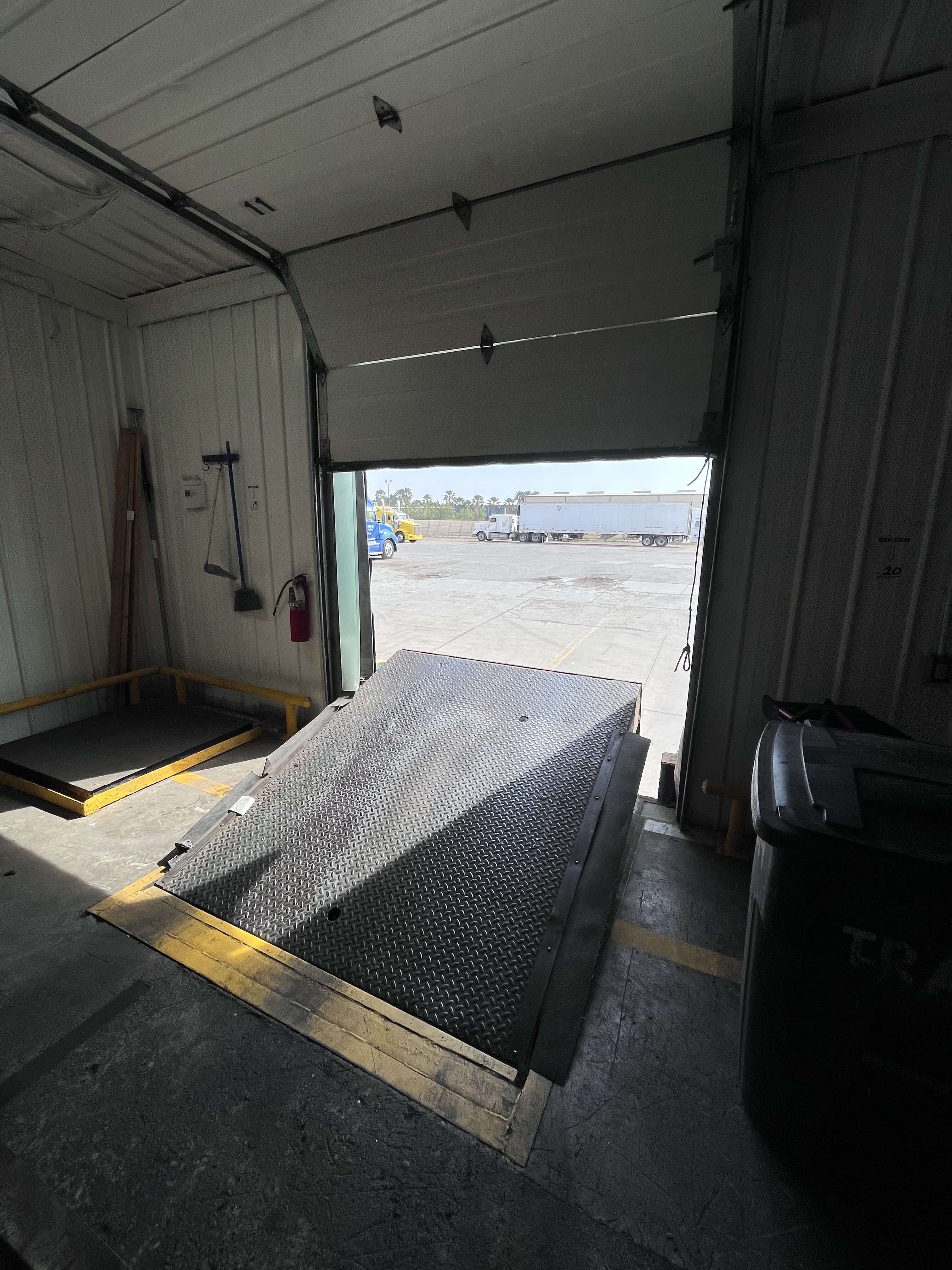 Open dock bay showing truck yard with refrigerated trailers